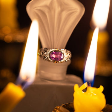 1.16ct natural alexandrite ring in 18k white gold with vintage diamond accents and yellow gold heart details displayed among candlelight